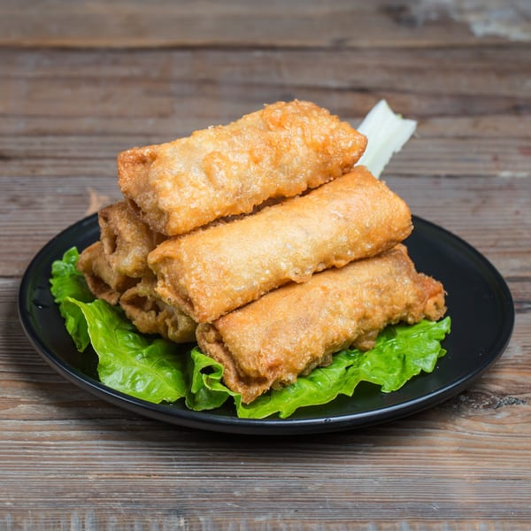 Crispy golden Vietnamese egg rolls, known as Cha Gio, served on a bed of fresh lettuce.